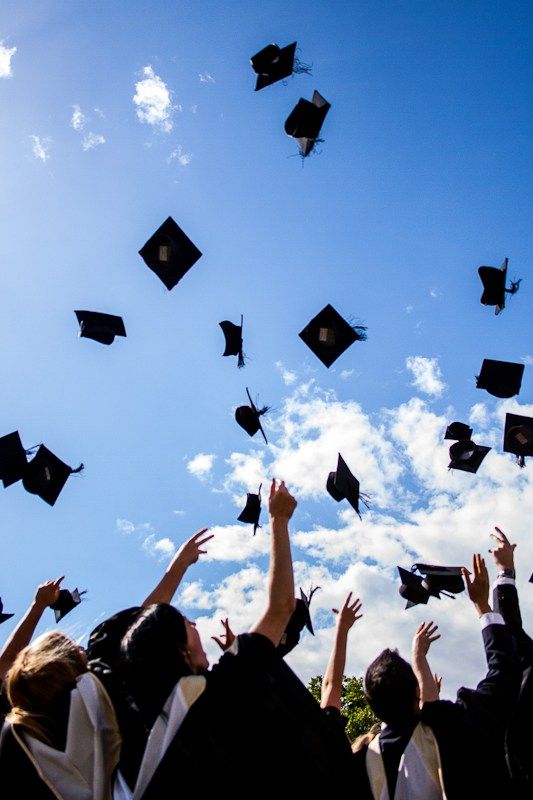 a group of graduates throwing their caps in the air