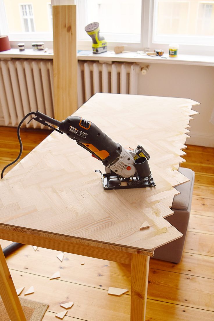 a table with a driller on top of it and some wood planks around it