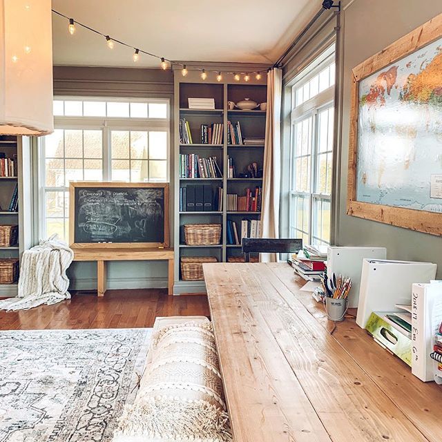 a living room filled with furniture and bookshelves next to a large wooden table