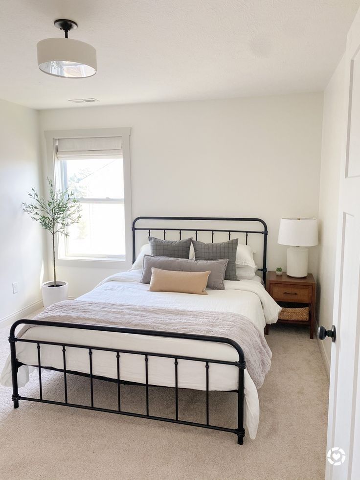 a bedroom with a bed, nightstands and window in it's center area