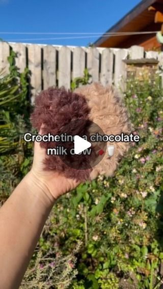 someone is holding up a teddy bear in their hand with the words crocheting chocolate milk