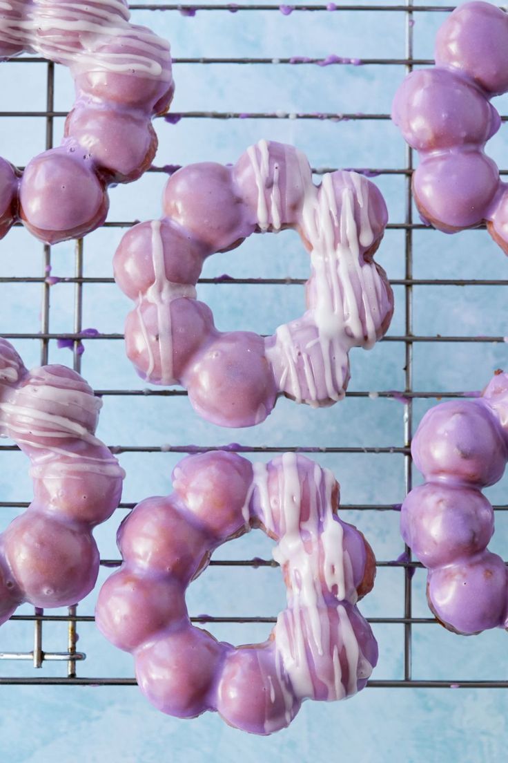 donuts with frosting and sprinkles are on a cooling rack, ready to be eaten