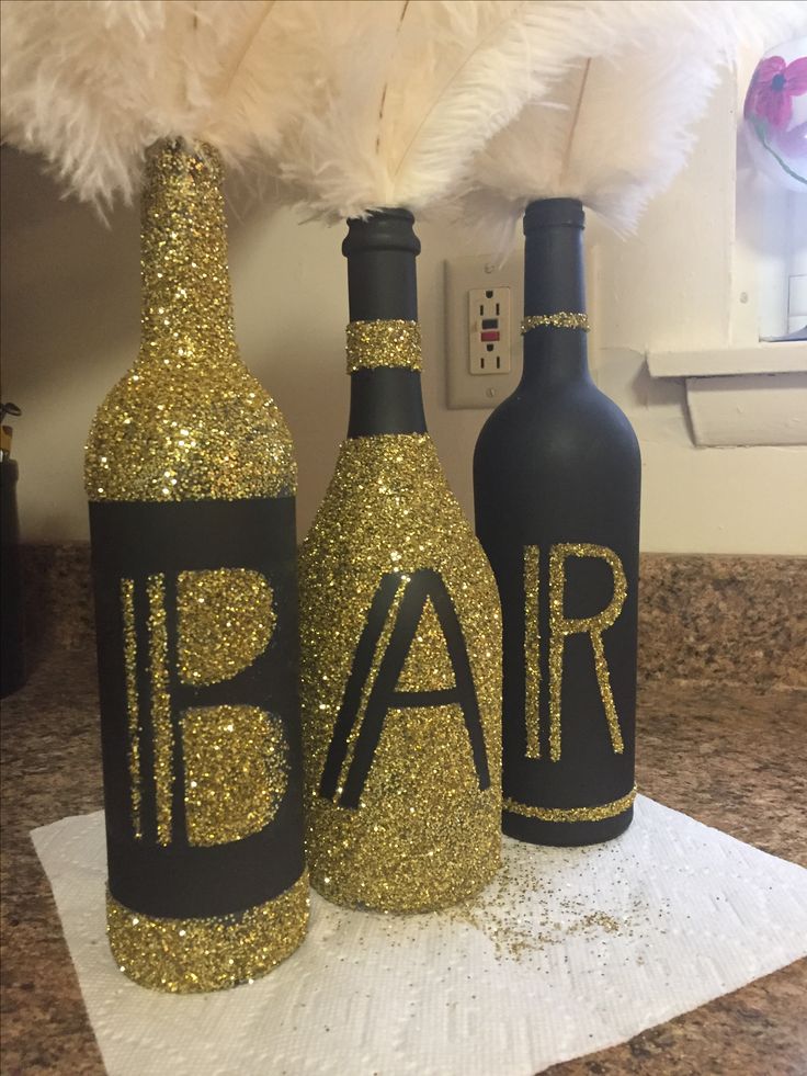 two wine bottles decorated with gold glitter and the word bar