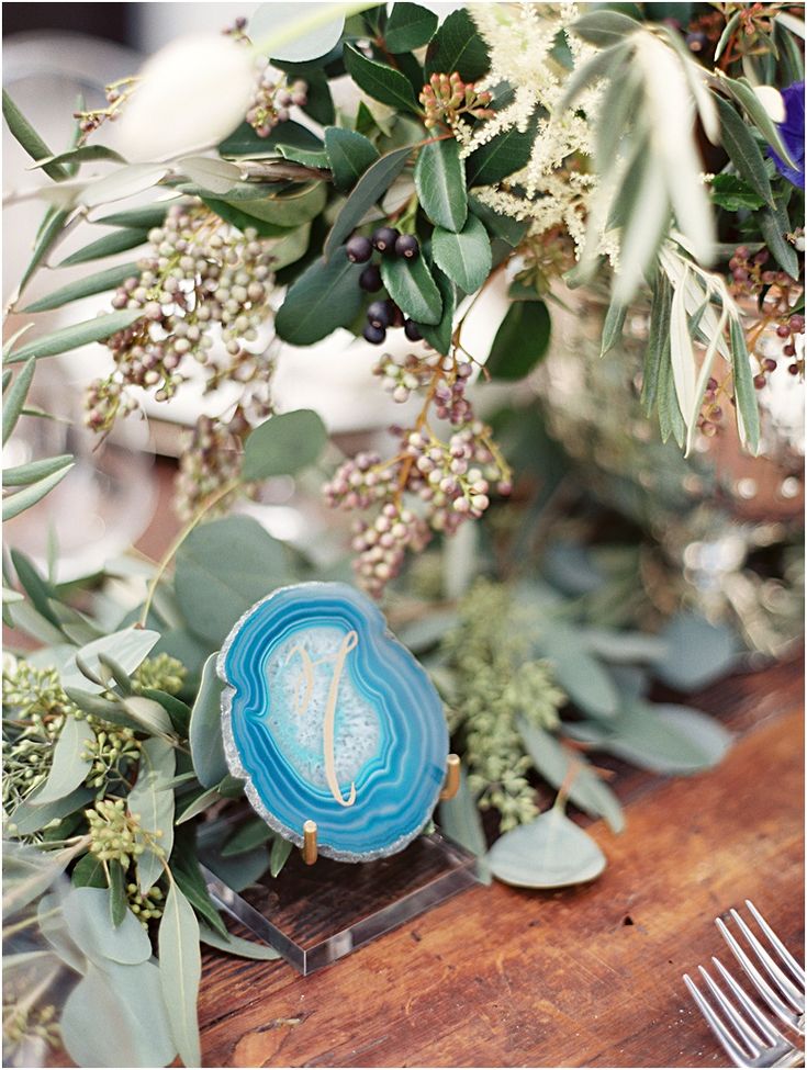 the table is decorated with greenery and blue agate