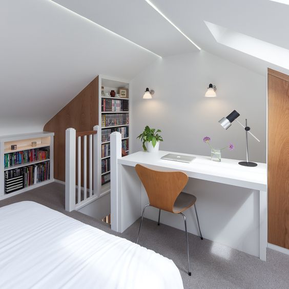 a bedroom with a desk, bookshelf and bookcases in the corner