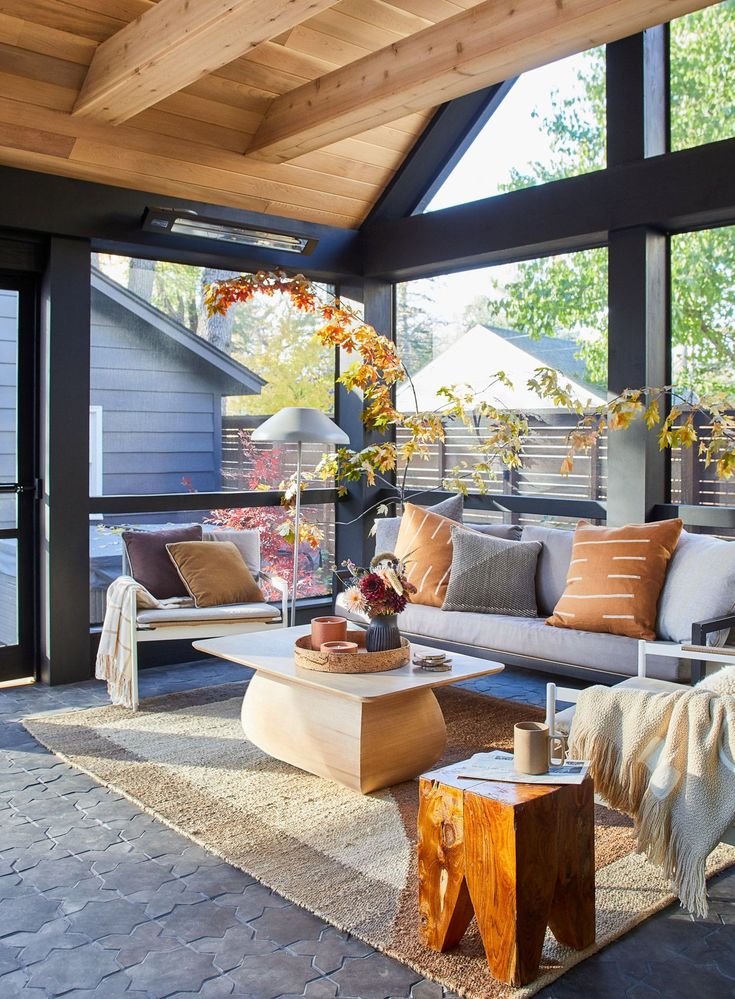 a living room filled with lots of furniture and windows covered in wooden planks on top of