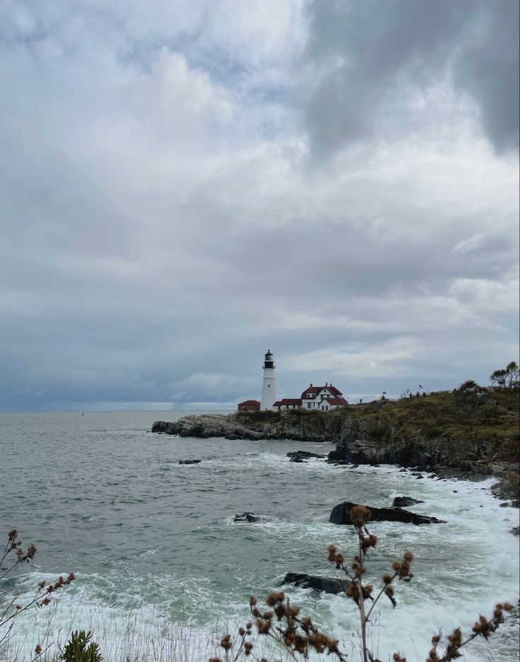 a lighthouse on top of a cliff near the ocean