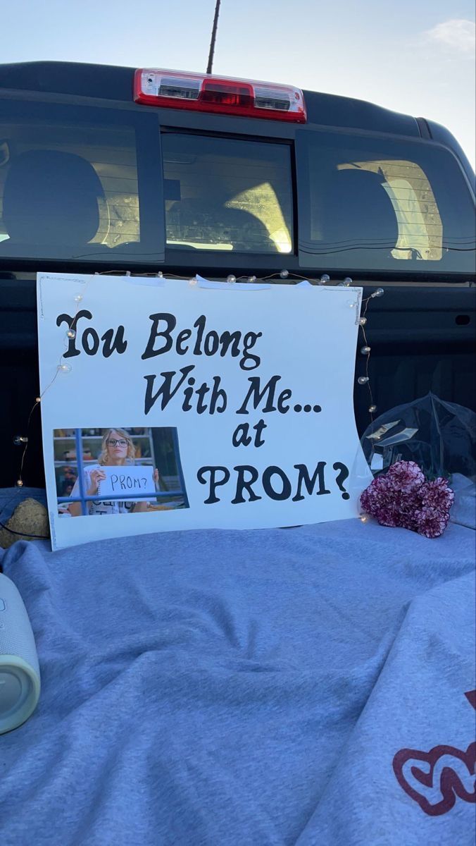 a sign on the back of a truck that says you belong with me at prom