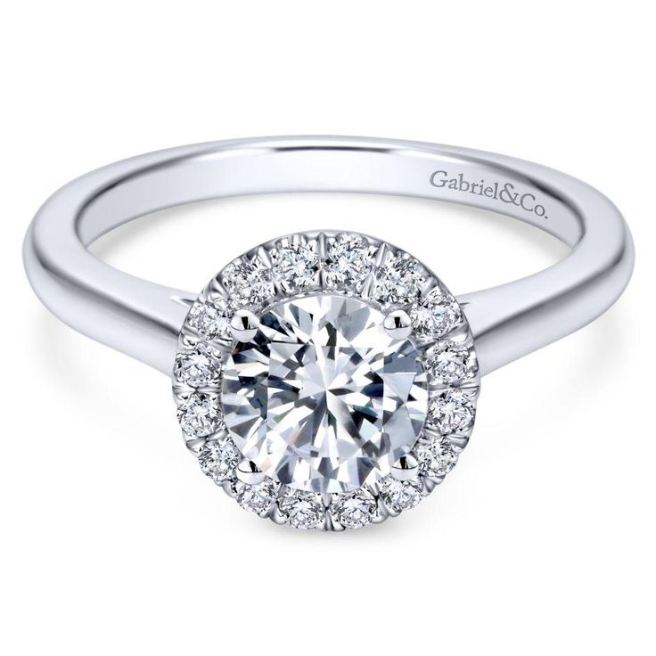 a white gold halo style engagement ring with round diamonds on the shans and shoulders