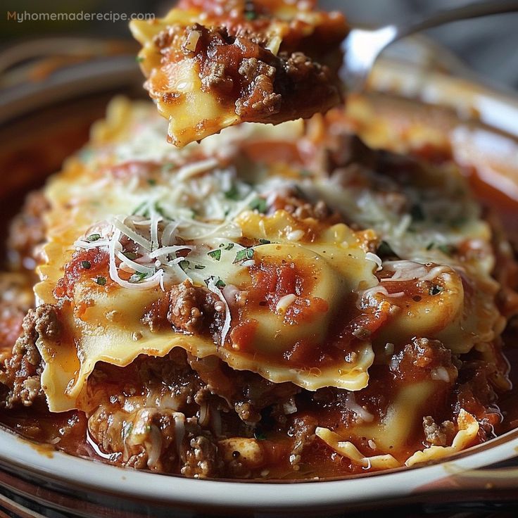 a spoon full of lasagna with meat and cheese