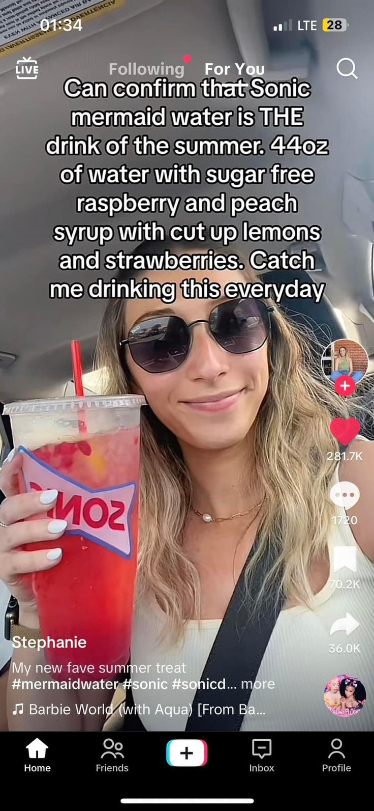 a woman holding a drink in her hand while sitting in the back seat of a car