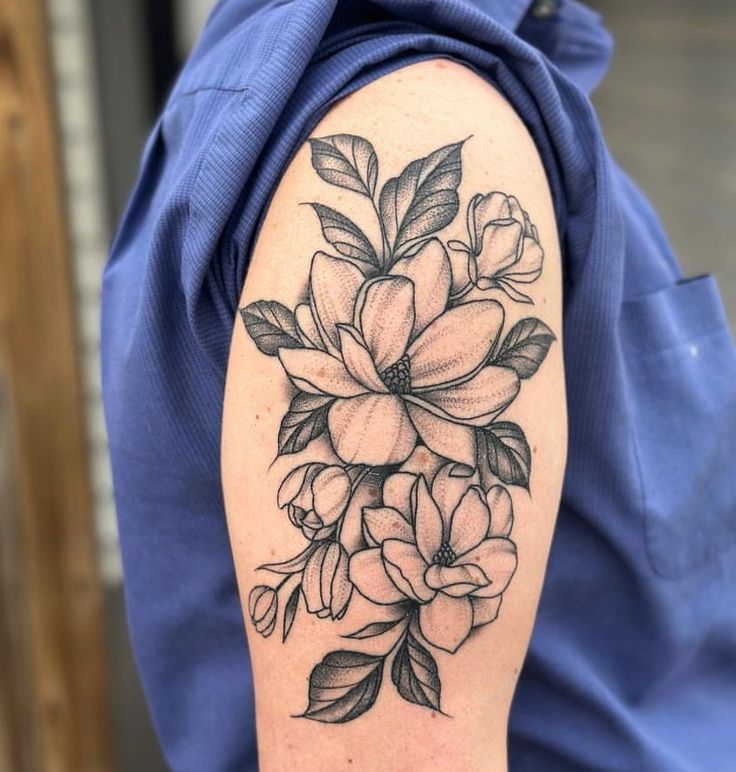 a black and white flower tattoo on the arm