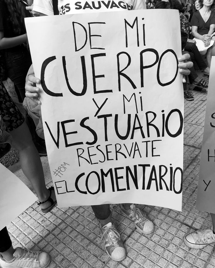 people holding up signs in spanish and english