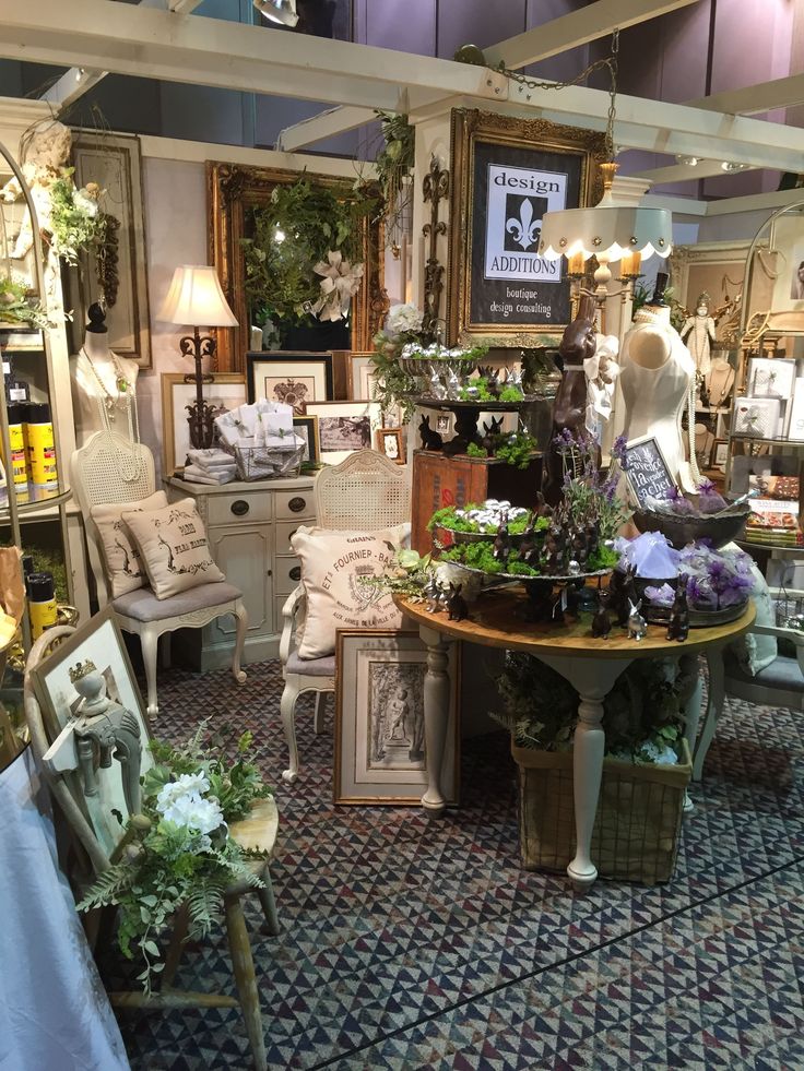 a room filled with lots of furniture and flowers in vases on the table next to chairs