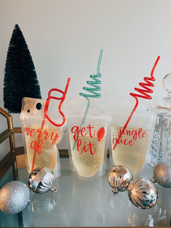 three glasses sitting on top of a table next to christmas ornaments and a small tree