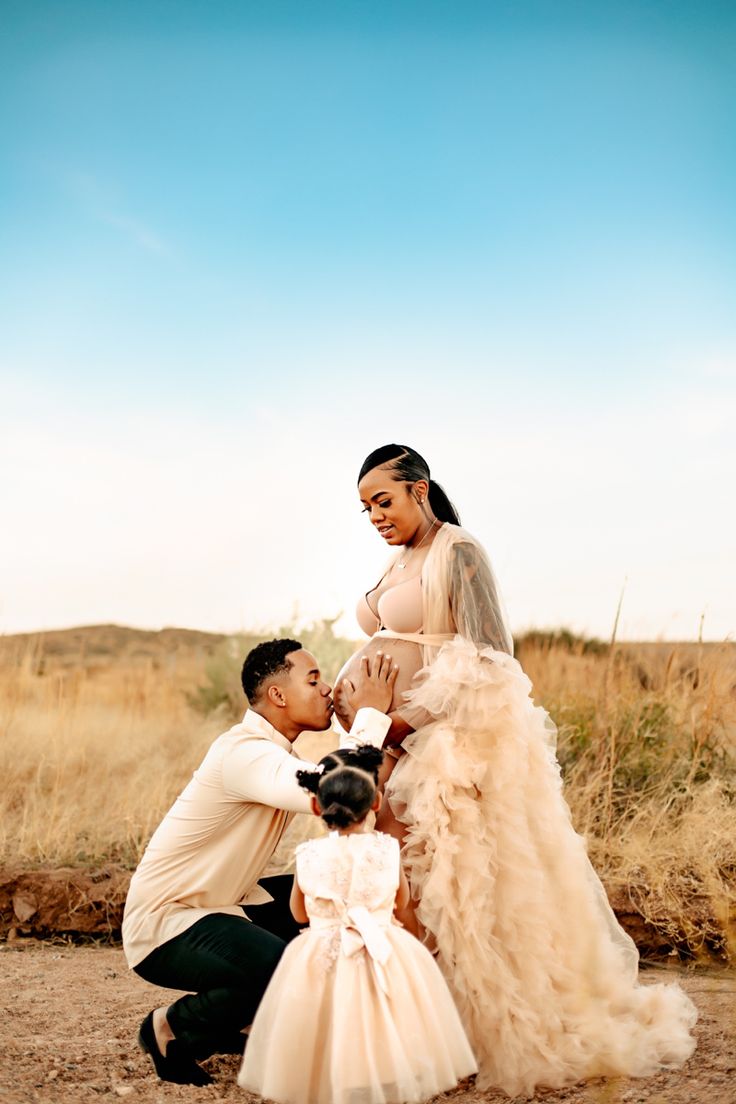 a man kneeling down next to a woman in a wedding dress