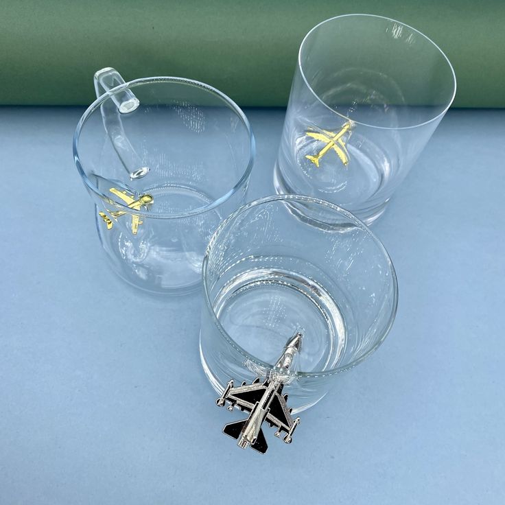 two clear glasses with yellow and black charms on them