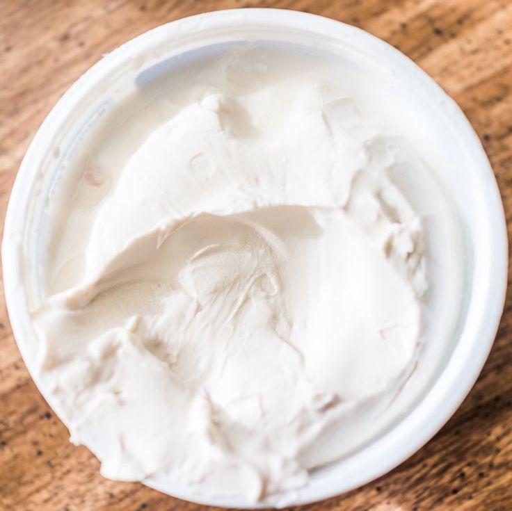 a white bowl filled with whipped cream on top of a wooden table