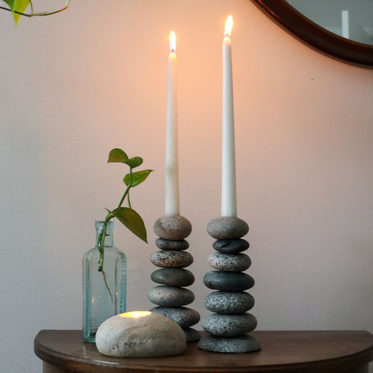 two candles and some rocks on a table