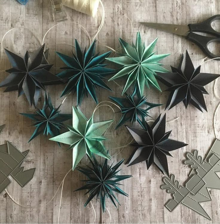 some paper flowers and scissors are on the table next to each other, which is decorated with string