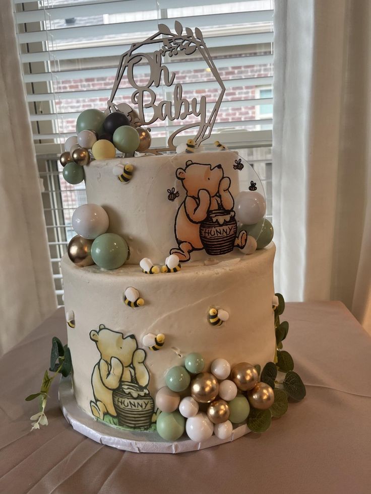 a three tiered cake decorated with balloons and teddy bears is on a table in front of a window