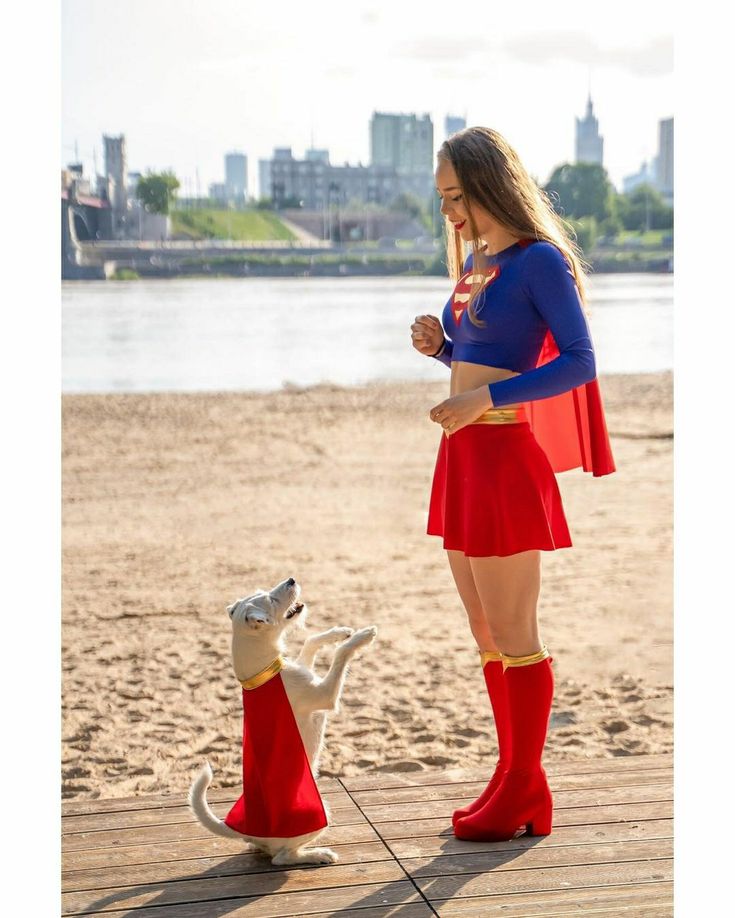 a woman in a costume standing next to a dog