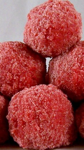 a pile of red donuts sitting on top of a white table cloth covered in powdered sugar