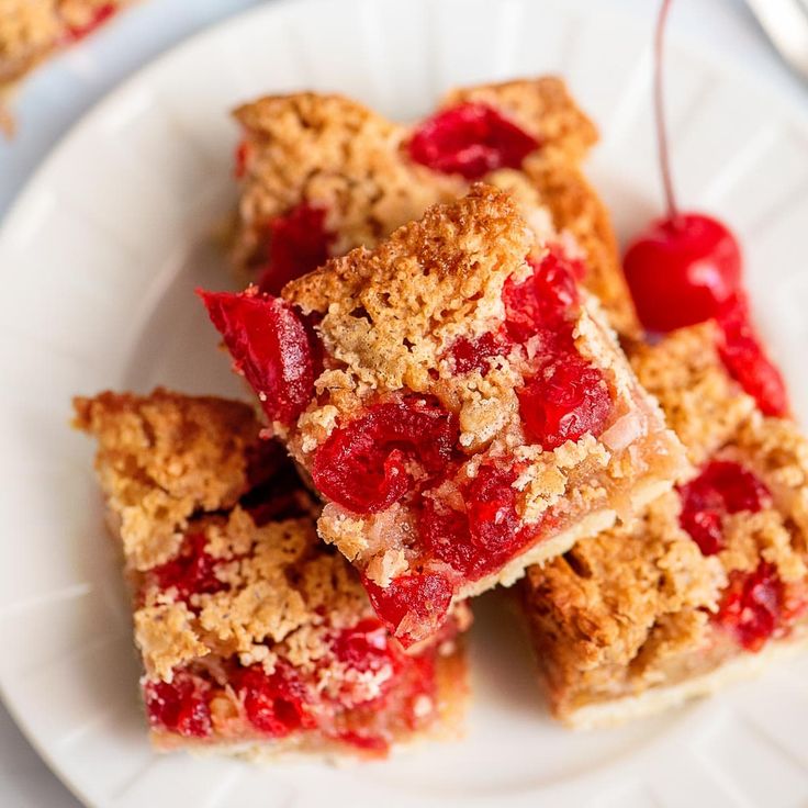 several pieces of cherry crumb bars on a white plate