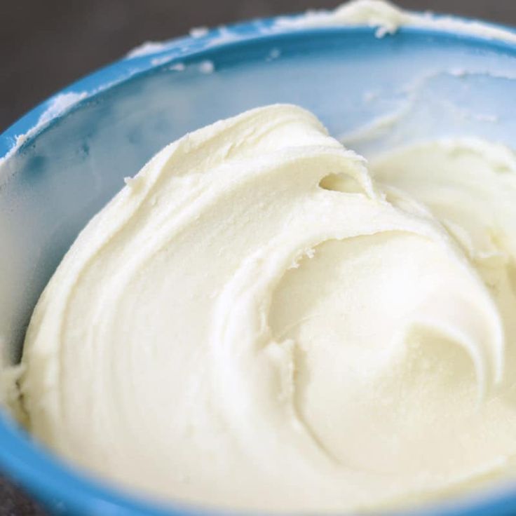 a blue bowl filled with cream on top of a table