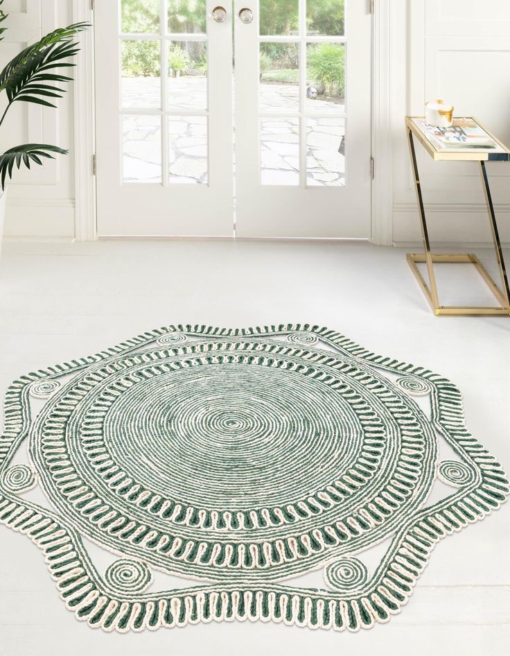 a green and white area rug with an intricate design on the floor in front of a door