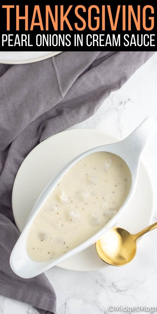 a white bowl filled with cream sauce on top of a marble counter next to a gold spoon