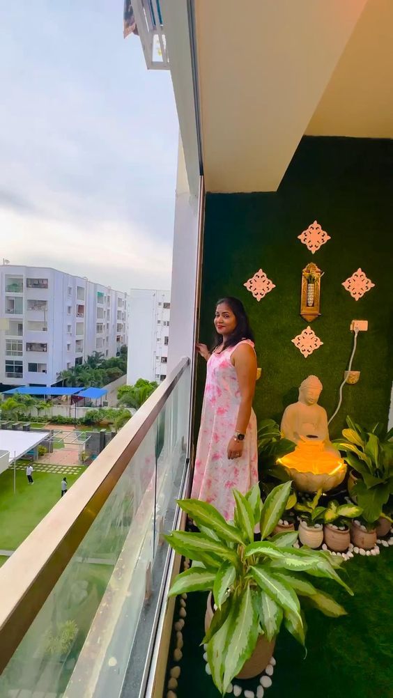 a woman standing in front of a window next to a potted plant on top of a balcony