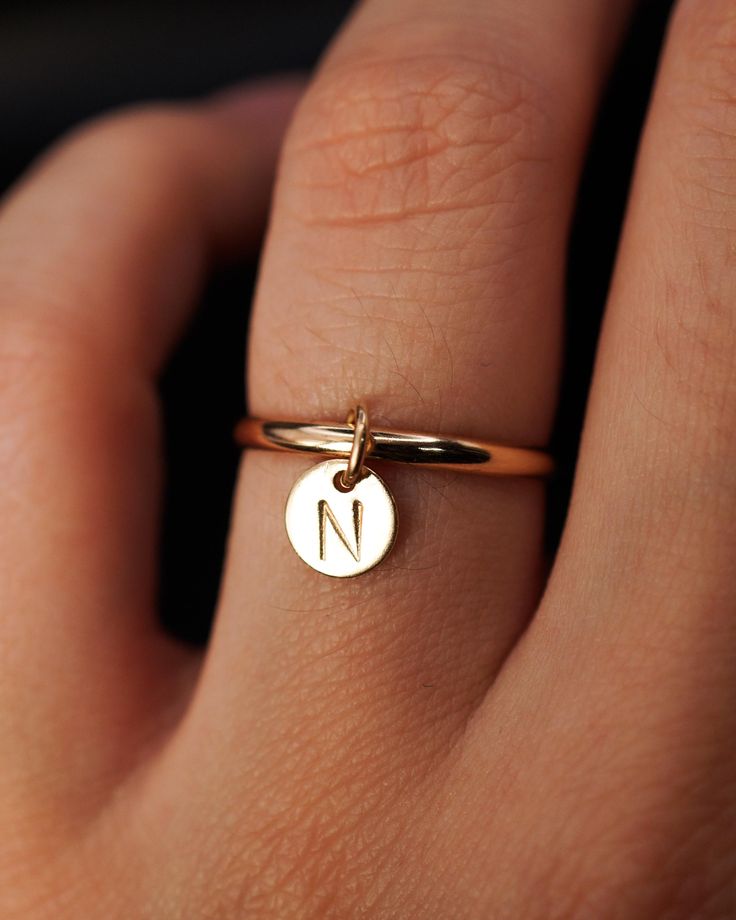 Introducing the Monogram Charm Ring! This handcrafted ring features an extra thick, smooth band made from high-quality 14k Gold Fill. Adorning the band is a dangle charm in the shape of a tiny, circular disc that can be personalized with your initial or the initial of someone special, making it a truly sentimental piece. The charm is carefully stamped with precision, adding a handmade touch to this design. This listing is for ONE single Monogram Charm Ring made up of: 1x Extra Thick, Smooth Ring Big Diamond Engagement Rings, Stamping Jewelry, Charm Ring, Thick Ring, Letter Ring, Big Diamond, Handcrafted Rings, Charm Rings, Dangle Charms