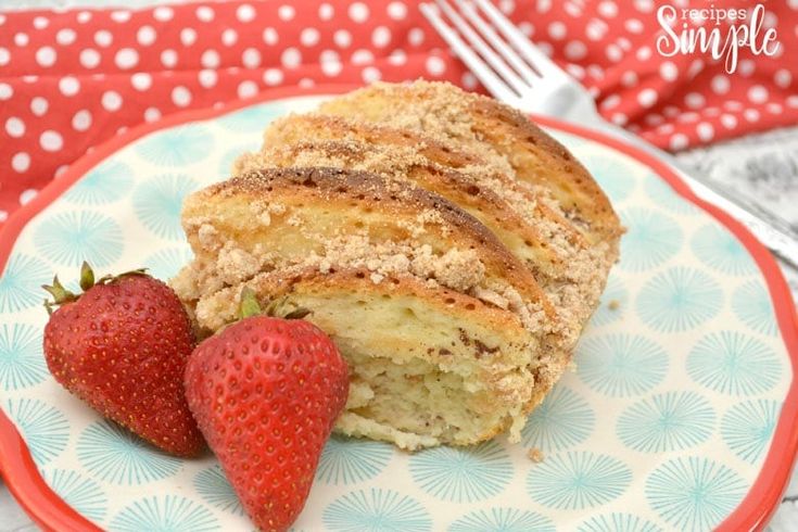 a piece of cake and two strawberries on a plate