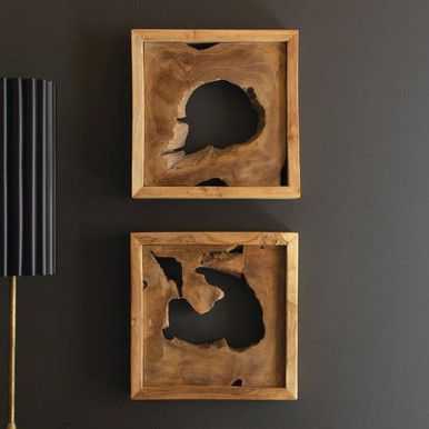 two square wooden frames with holes in them on a wall next to a lamp and table