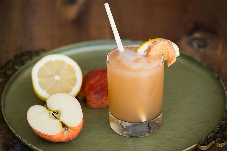 an apple and orange drink on a green plate