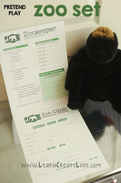 a stuffed animal sitting on top of a desk next to a zoo set paper sheet