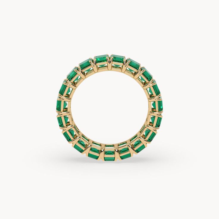 The Eden Eternity Ring Small captivates with its refined elegance and the impressive beauty of 4 mm lab-grown emeralds. Set in 14-karat recycled gold, one sparkling emerald is placed next to the other, creating a continuous band of radiant green. This ring is a true masterpiece, shining brilliantly from every angle and adding a subtle yet striking accent to your style. Classic Green Eternity Promise Ring, Green Emerald Eternity Band Fine Jewelry, Classic Green Stackable Eternity Band, Classic Green Gemstone Eternity Band, Elegant Green Eternity Band For May Birthstone, Elegant Green May Birthstone Eternity Band, Luxury Yellow Gold Half Eternity Emerald Ring, Luxury Green Emerald Stackable Ring, Classic Green Round Cut Eternity Band