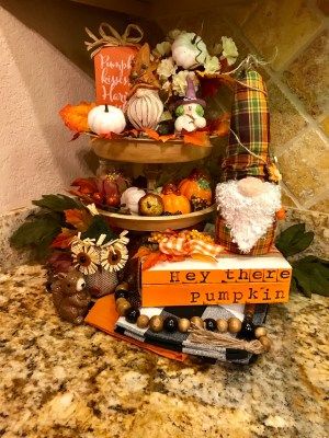 three tiered display with pumpkins and other decorations