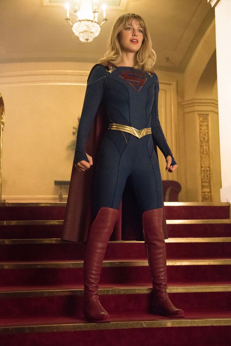 a woman in a superman costume standing on some steps with her hands on her hips