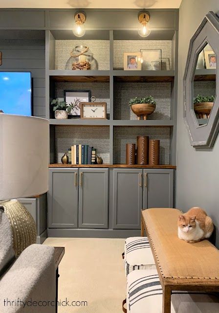 a cat sitting on top of a wooden table next to a couch in a living room