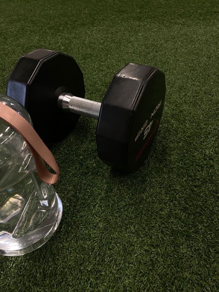 two dumbbells sitting on top of a green grass covered field next to each other