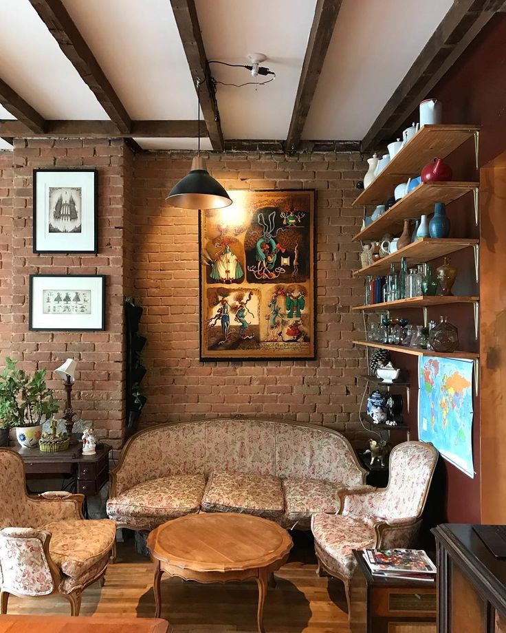 a living room filled with furniture next to a brick wall