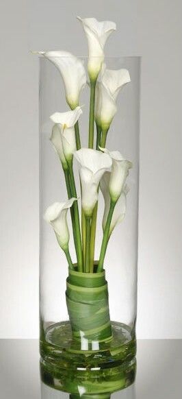 white flowers in a glass vase on a table