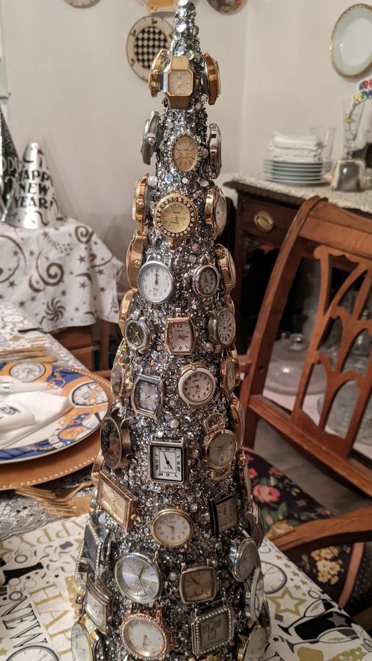 a christmas tree made out of watch parts on a table with plates and dishes in the background