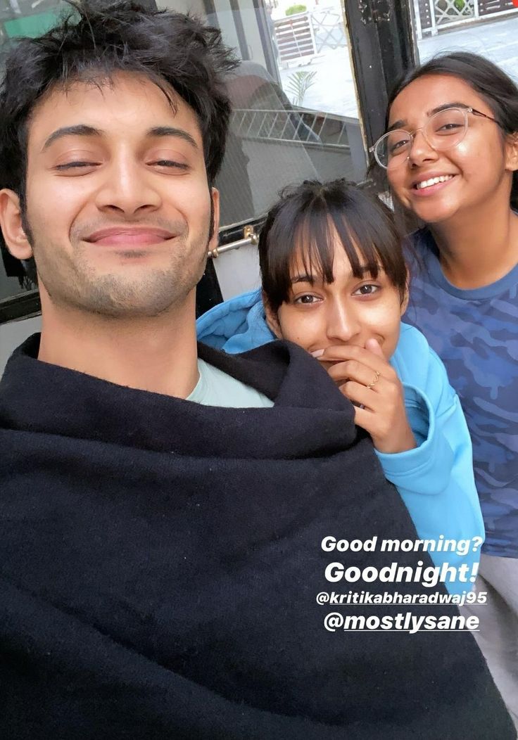 a man and two women wrapped in a blanket posing for the camera with their eyes closed