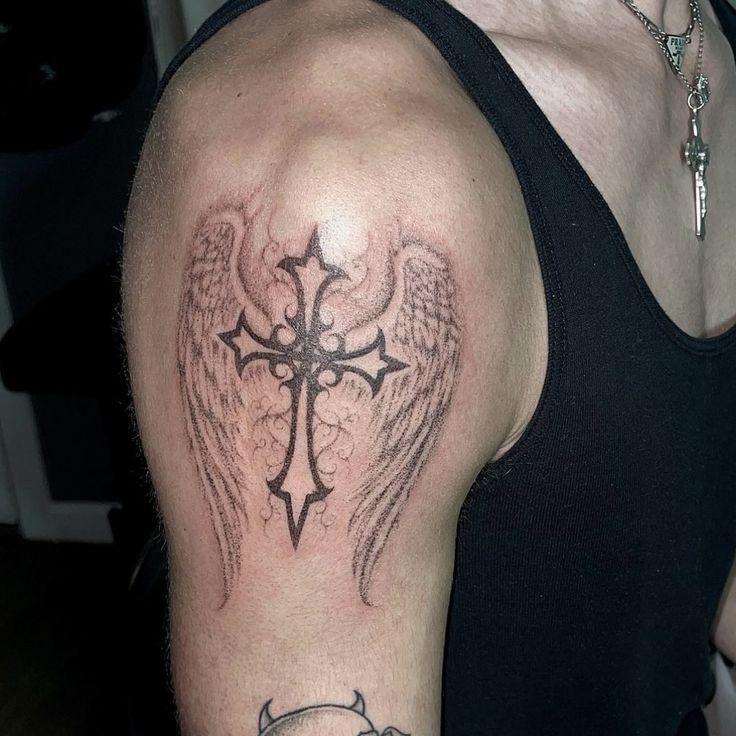 a cross with angel wings on the arm