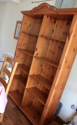 a wooden bookcase sitting on top of a hard wood floor