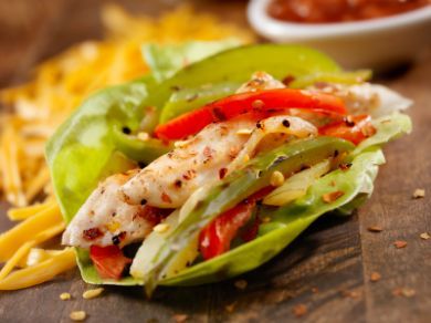 lettuce wraps with chicken and peppers on a cutting board