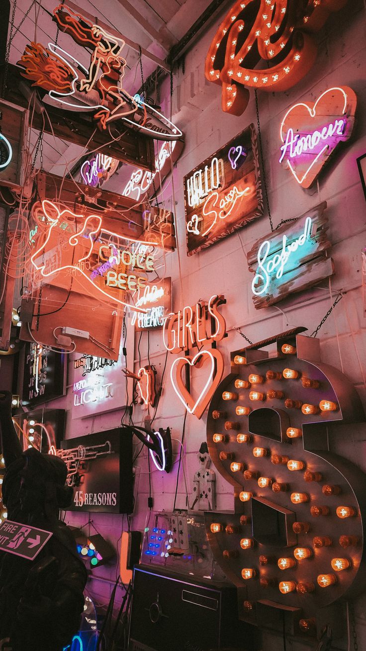 many neon signs are hanging on the wall